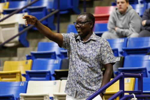 A man smiles and points at someone out of frame.