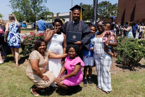 A family poses together with a graduate outside the Crown.