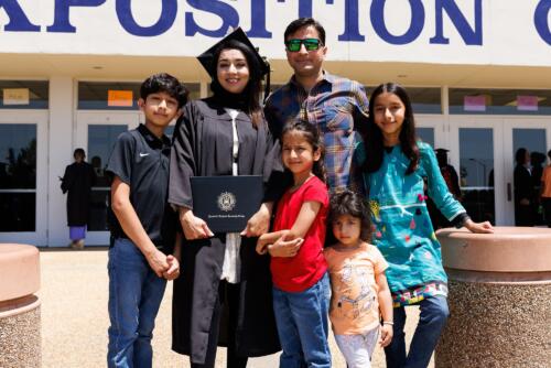 A woman in her cap and gown stands with a man and four children outside of the Crown.