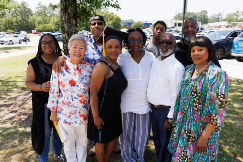 A graduate poses for a photo with a group of her loved ones outside the Crown.