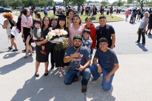 A graduate poses with a large group of her loved ones outside of the Crown.