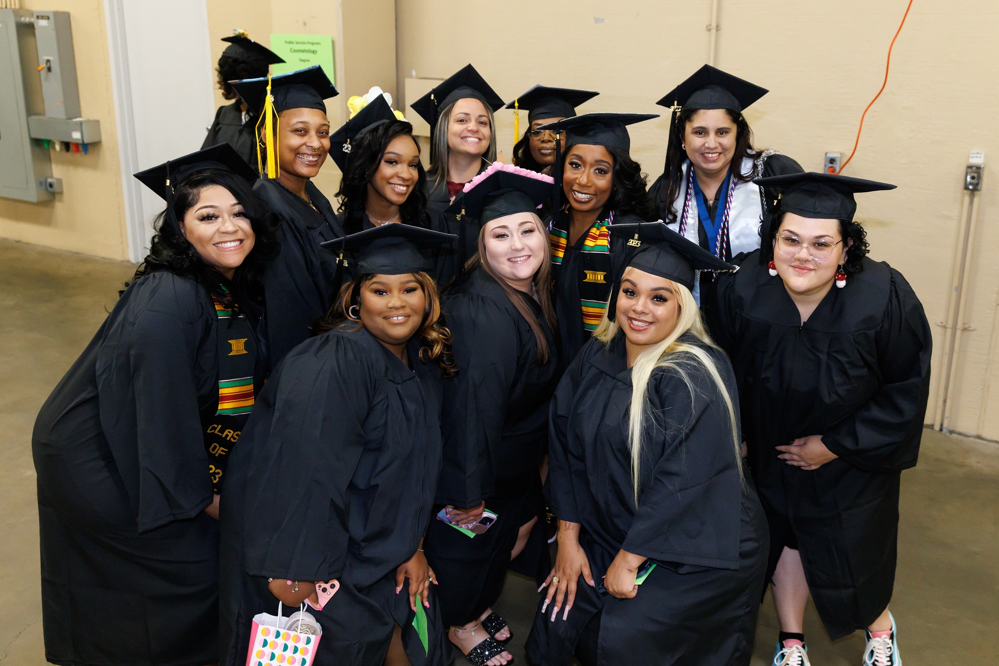 A group of graduates squeeze together to pose for a photo. 