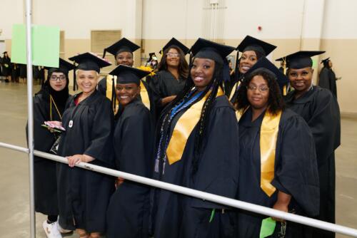 A group of graduates pose for a photo while they wait to line up in the staging area.