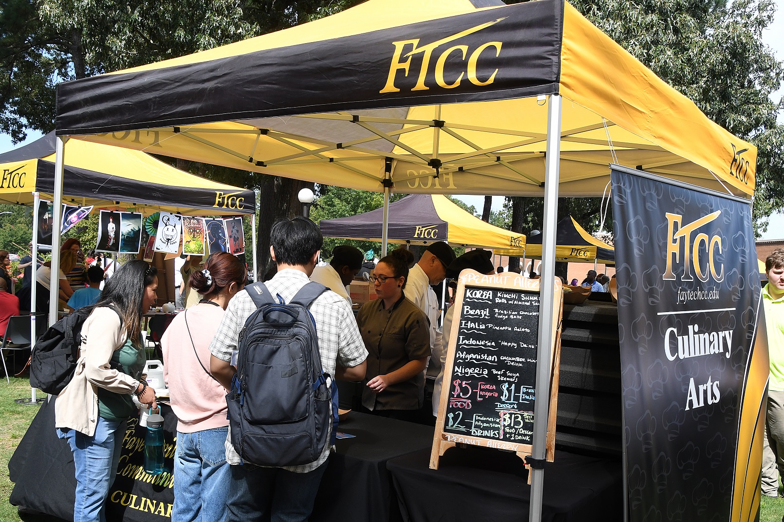 Students tries food at a Culinary Arts table.