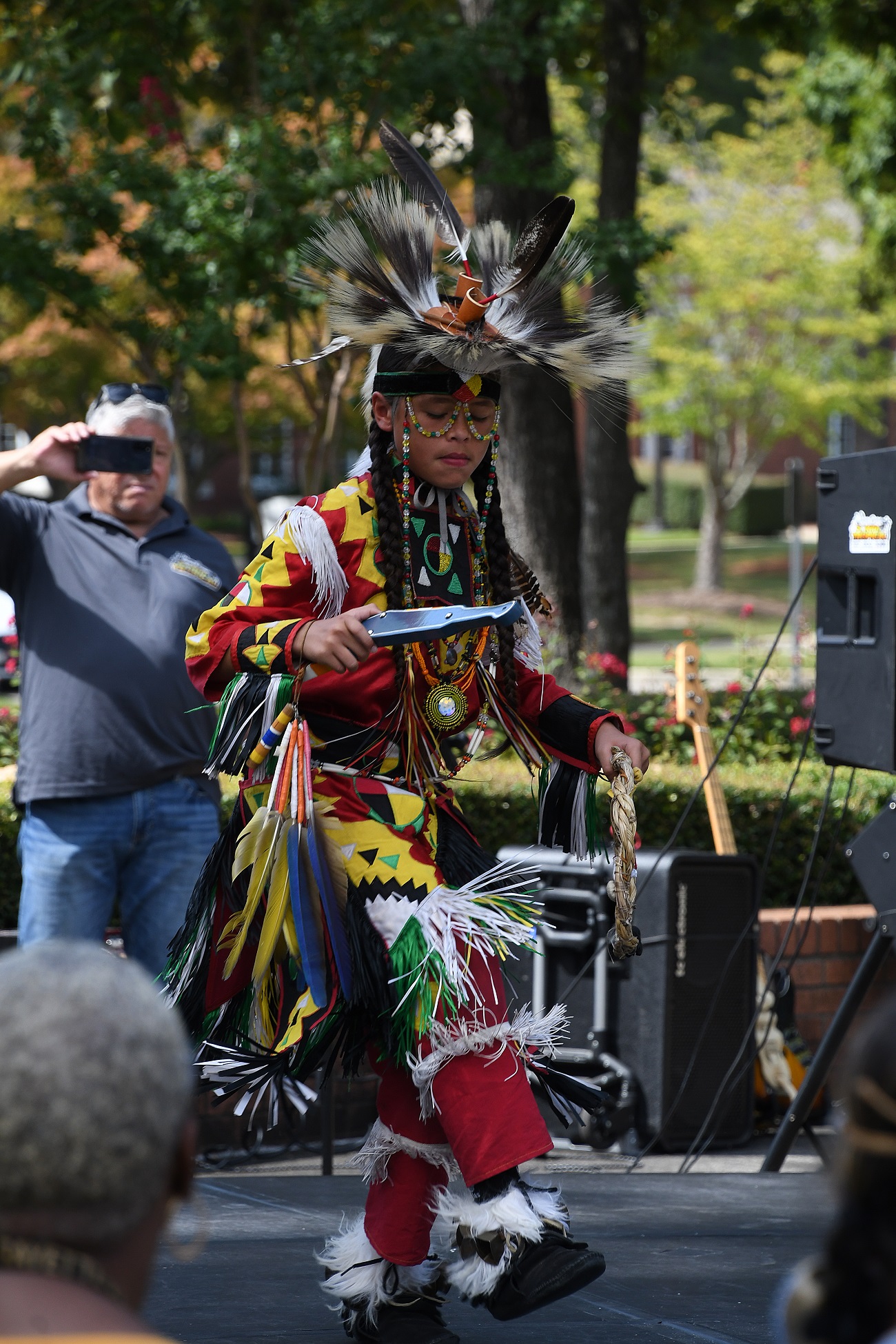 A Native American dancer performs on stage.