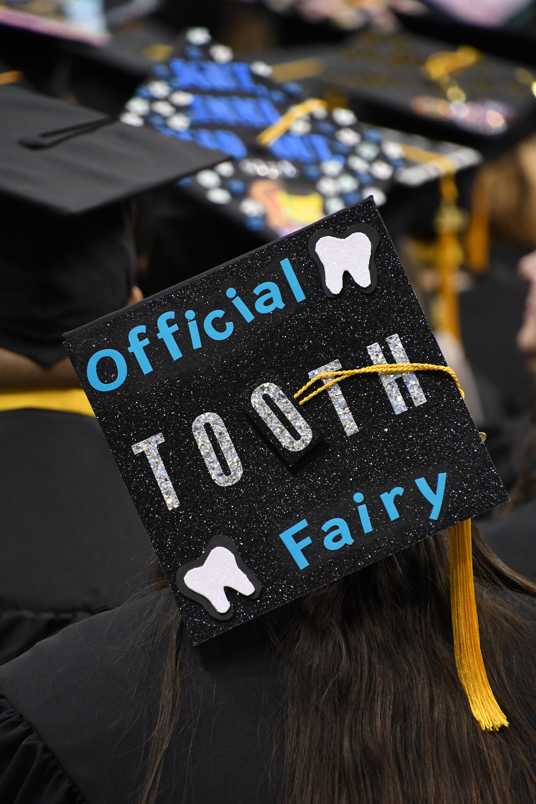 A graduation cap that says "Official Tooth Fairy"