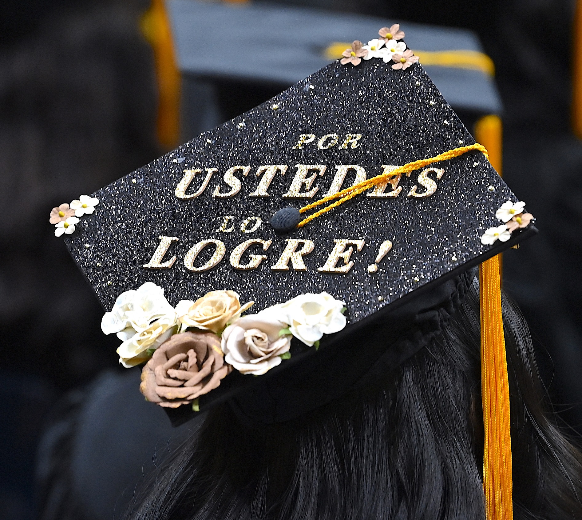 Un birrete de graduación que dice: "Por ustedes lo logre!"