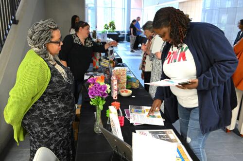 A visitor reads through the materials at a graduate's table during the showcase.