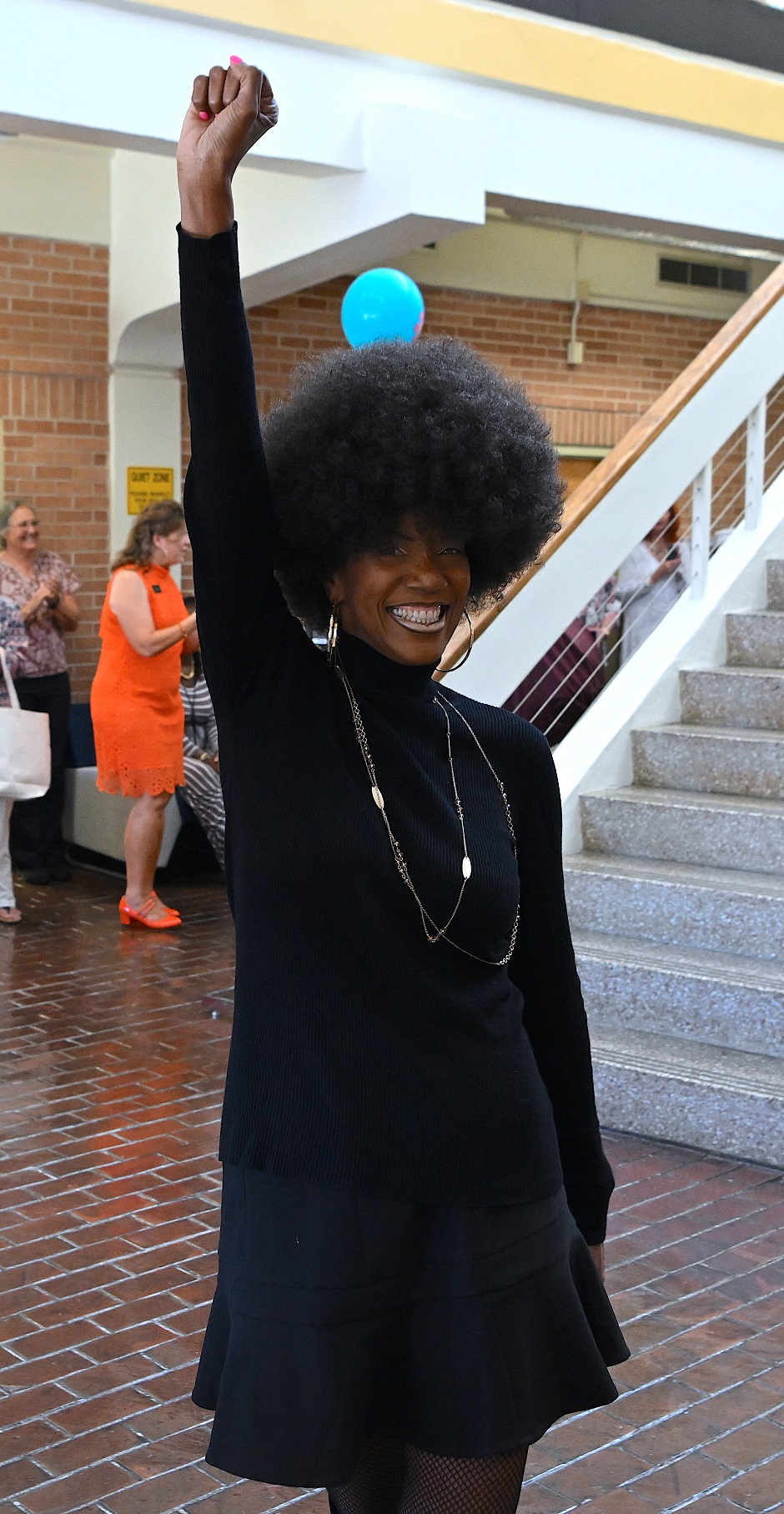 FTCC math instructor Tracy Welch, dressed Civil Rights activist Angela Davis, smiles and holds up a fist.