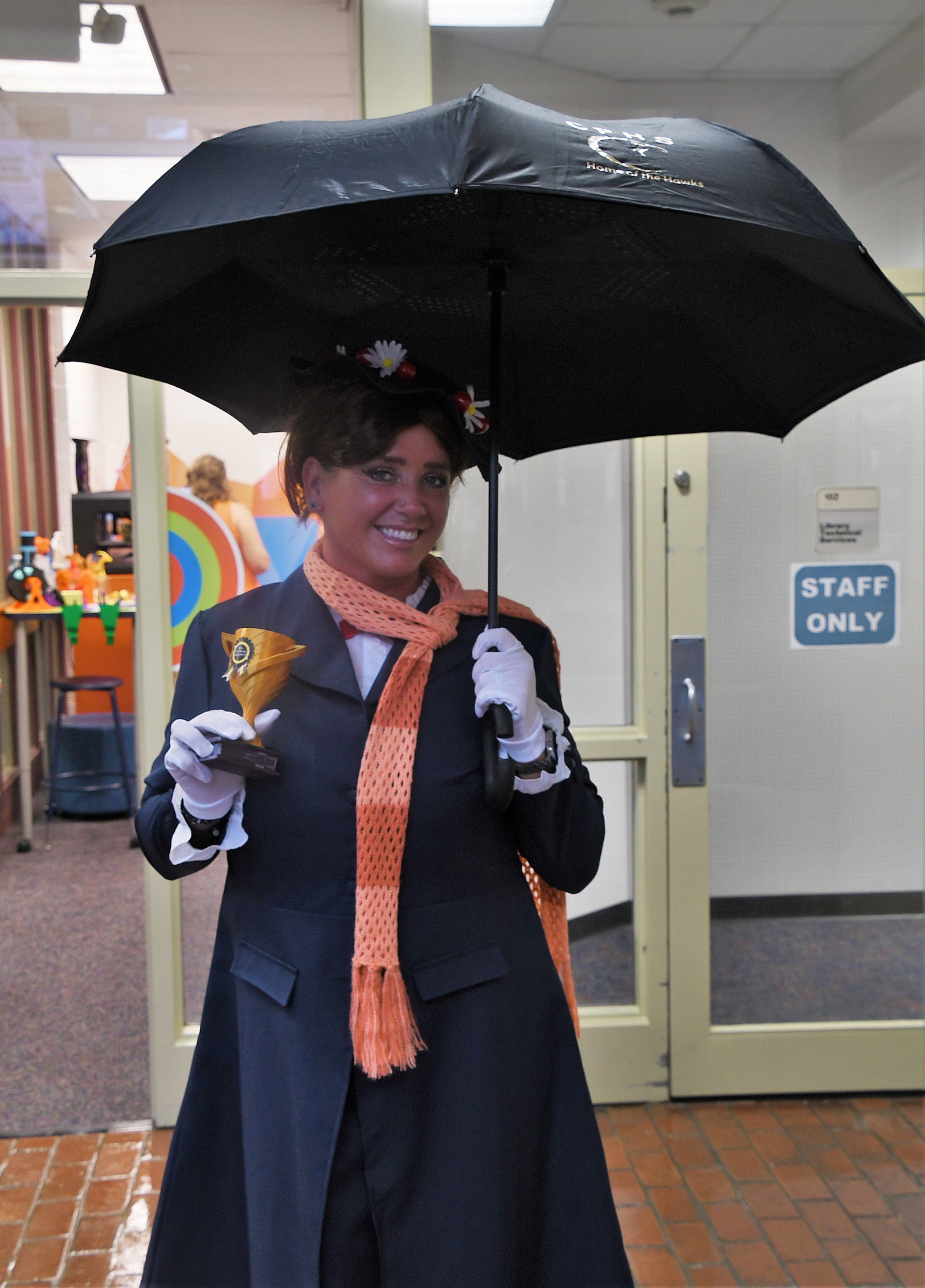 FTCC criminal justice instructor Jennifer Osborn, dressed as Mary Poppins, holds a trophy for winning the costume contest.