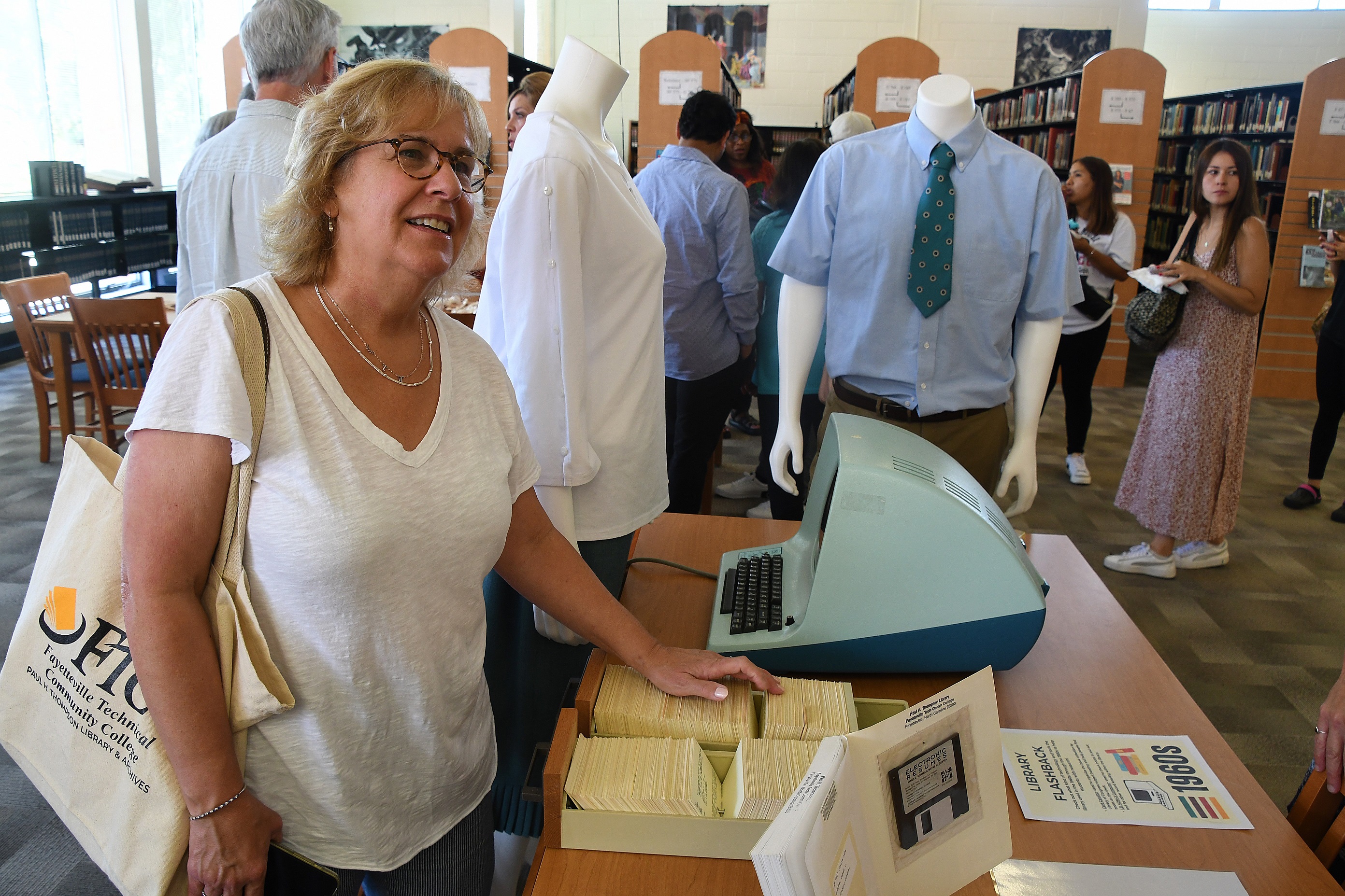 Library guests look at items from the 1960s on the display in the library.