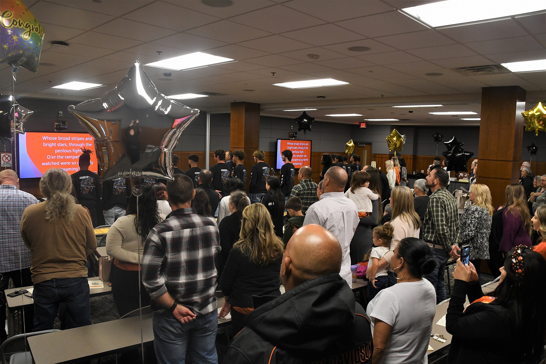 A photo showing the audience from behind during the national anthem.