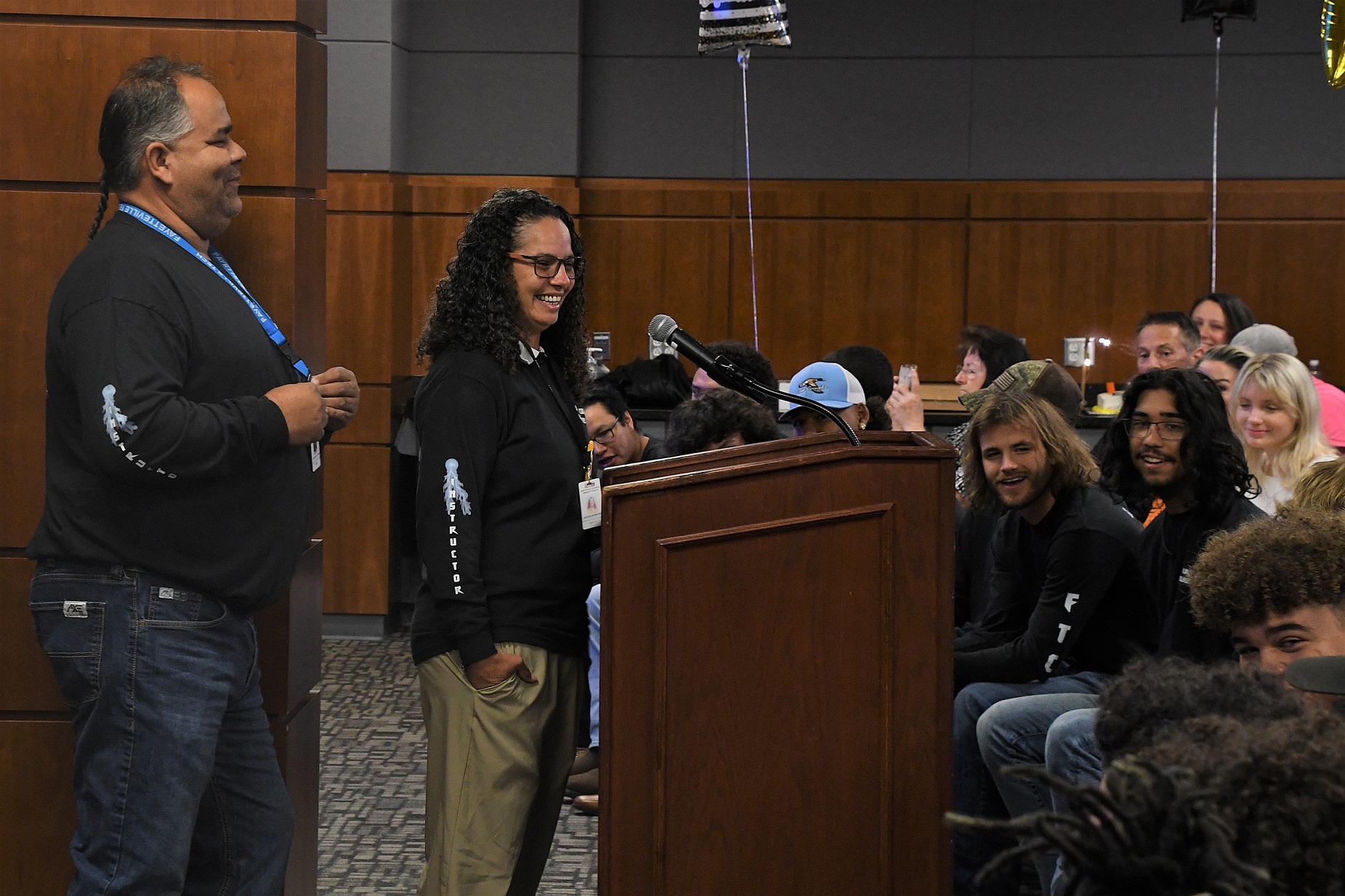 Electric Lineworker instructors Christopher Carter and Jacqueline Montero stand at the podium.