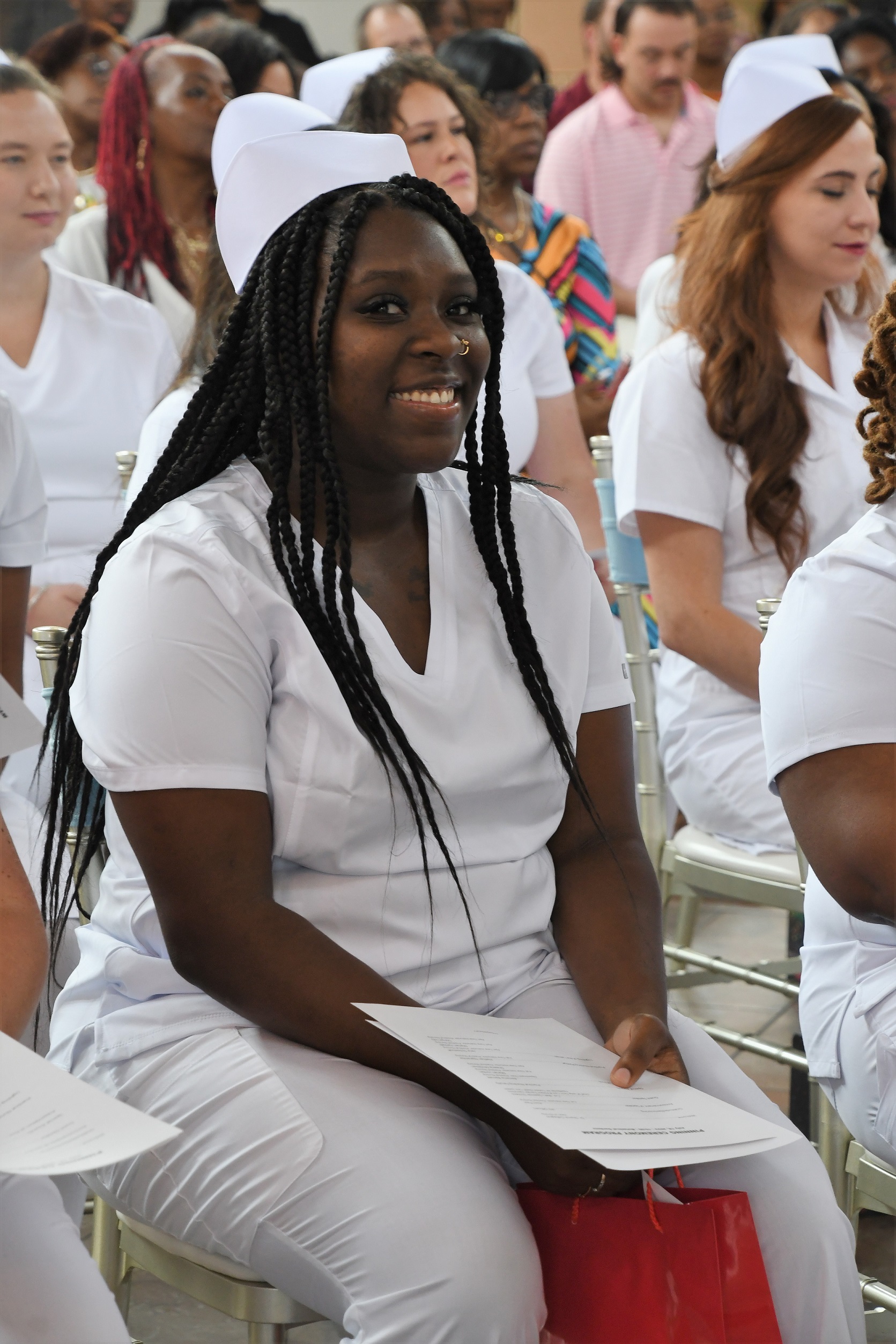 A seated graduate smiles at the camera.