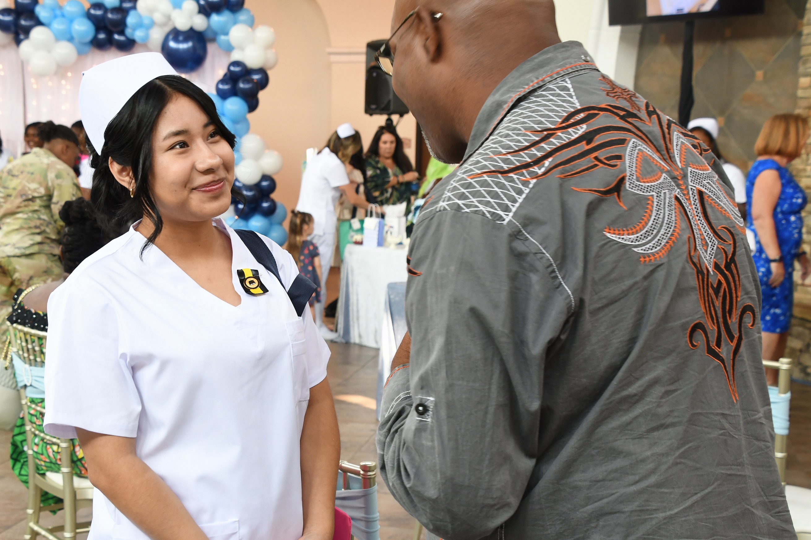 A LPN graduate talks with a man after the ceremony.