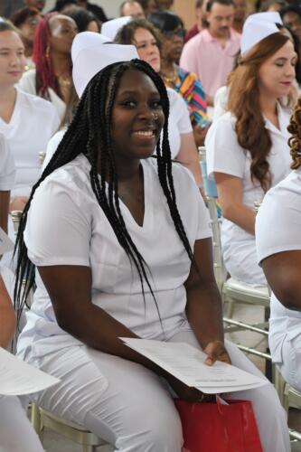 A seated graduate smiles at the camera.