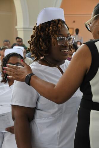 A graduate smiles as she waits to receive her pin during the ceremony.