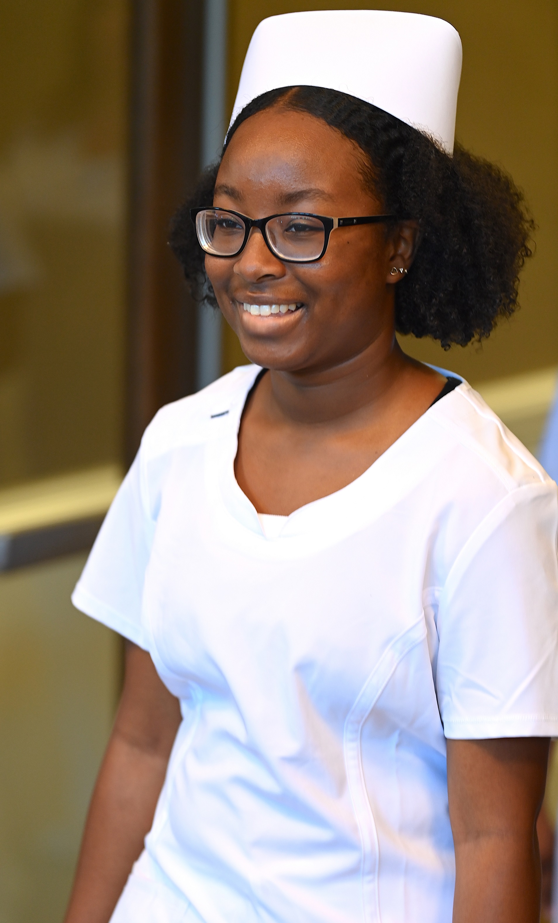 A nursing graduate walks in to the pinning ceremony.