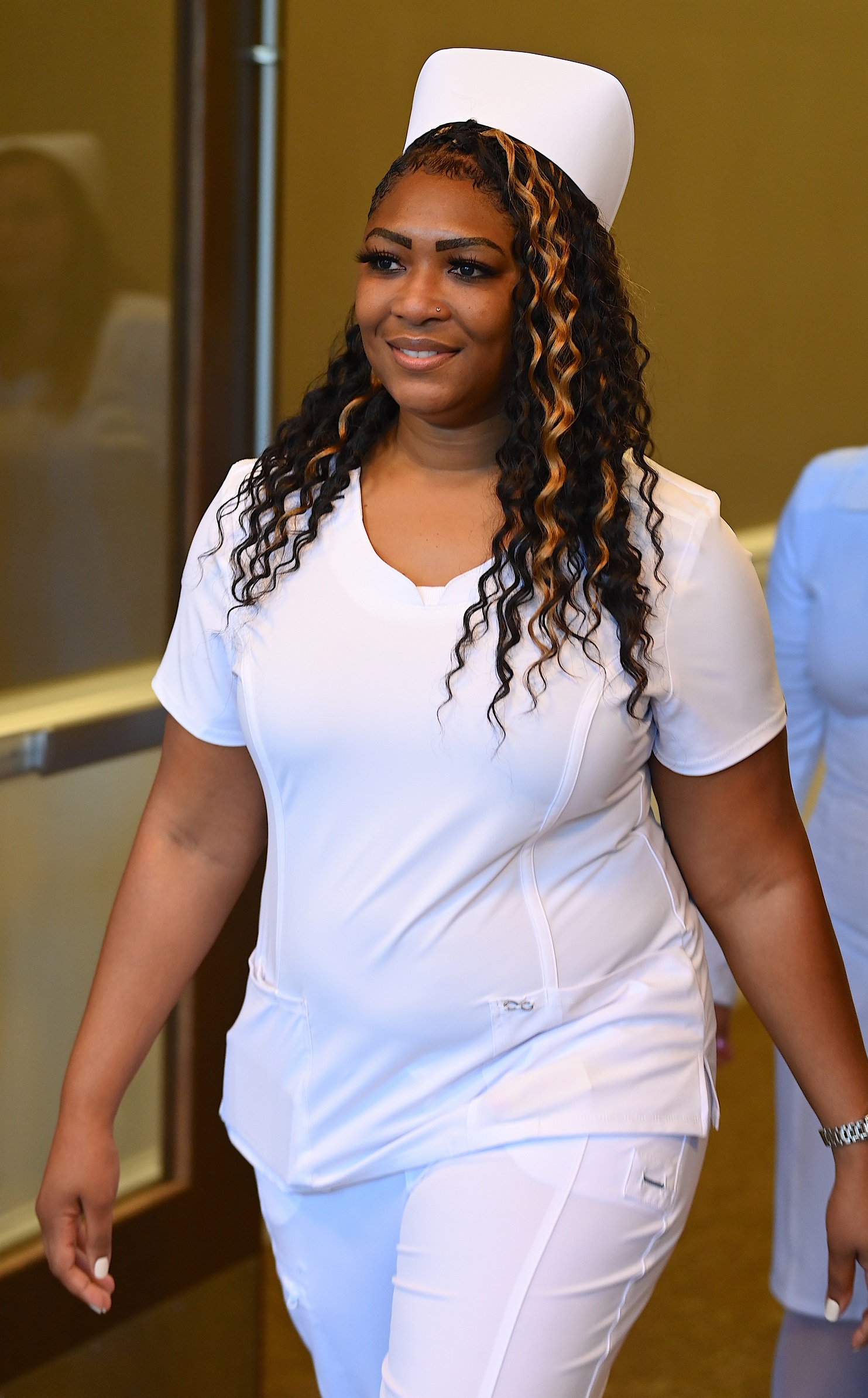 A nursing graduate walks in to the pinning ceremony.