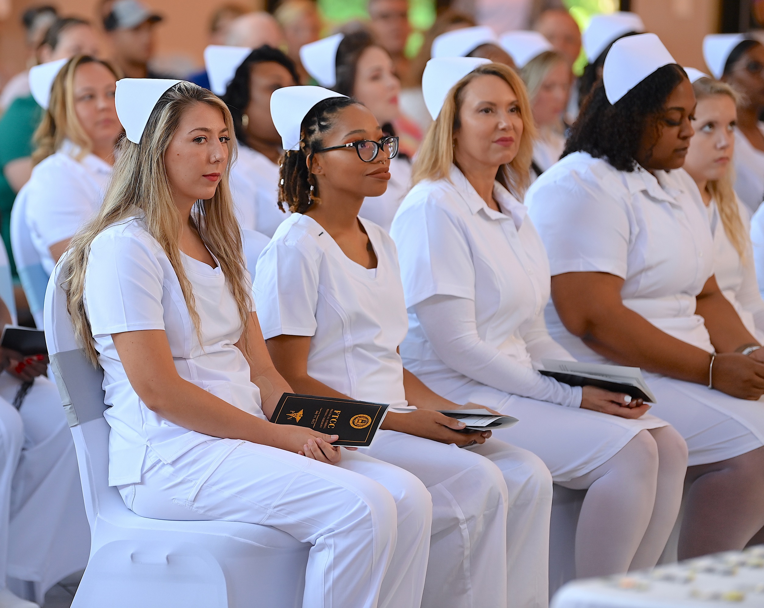 Nursing graduates sit at the pinning ceremony.