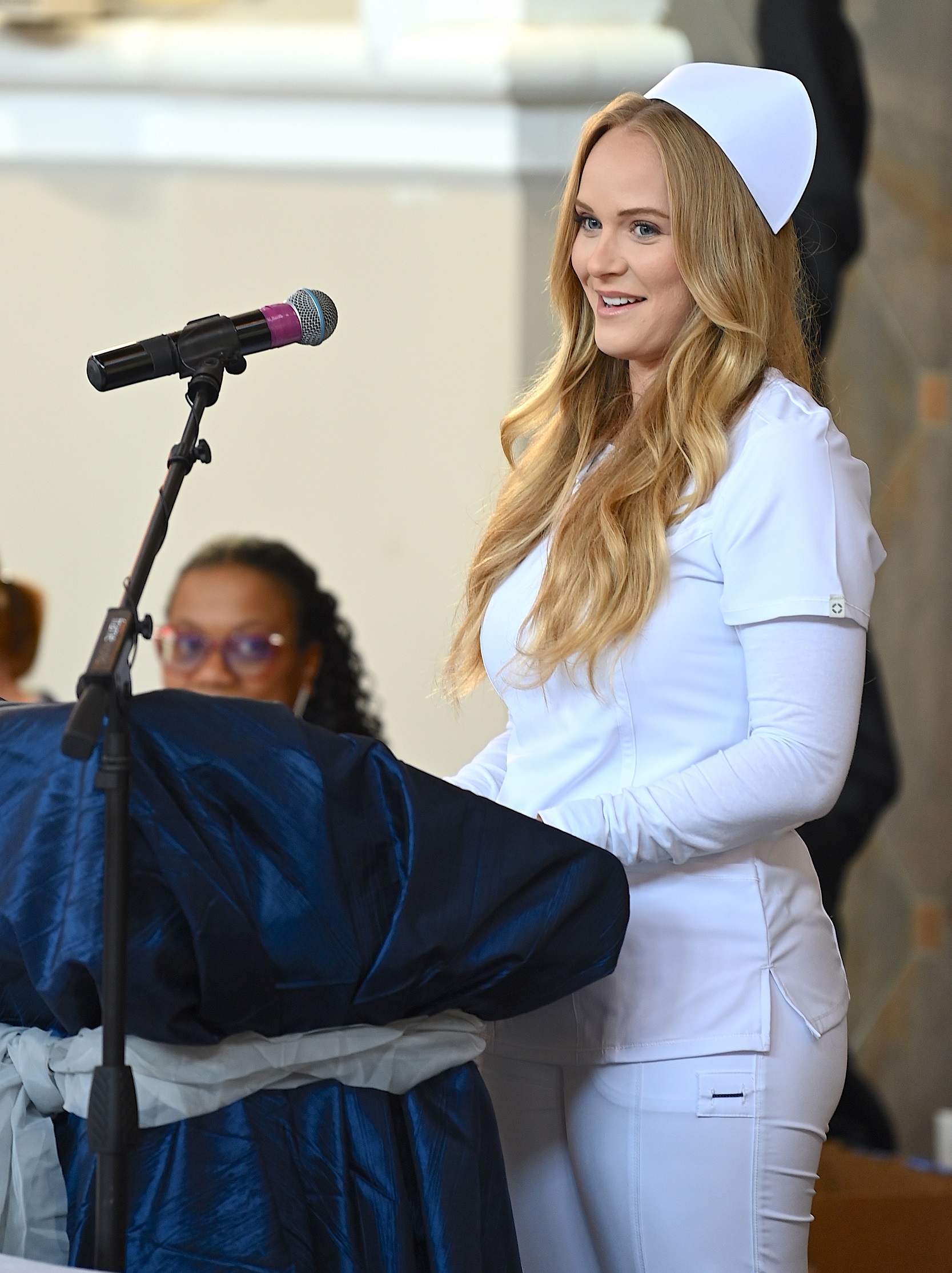 A nursing graduate speaks at the podium at the pinning ceremony.