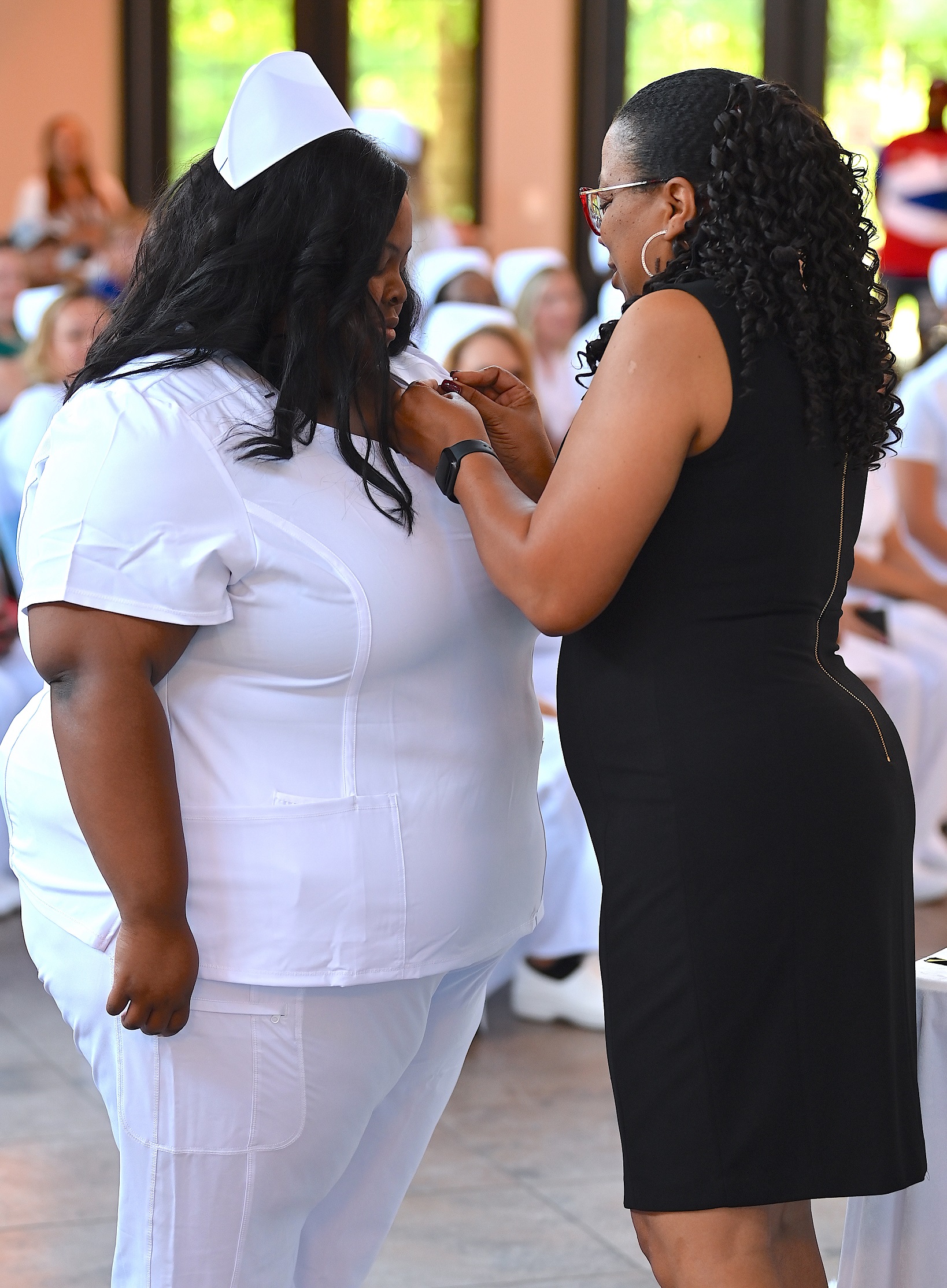 A nursing graduate receives her pin.