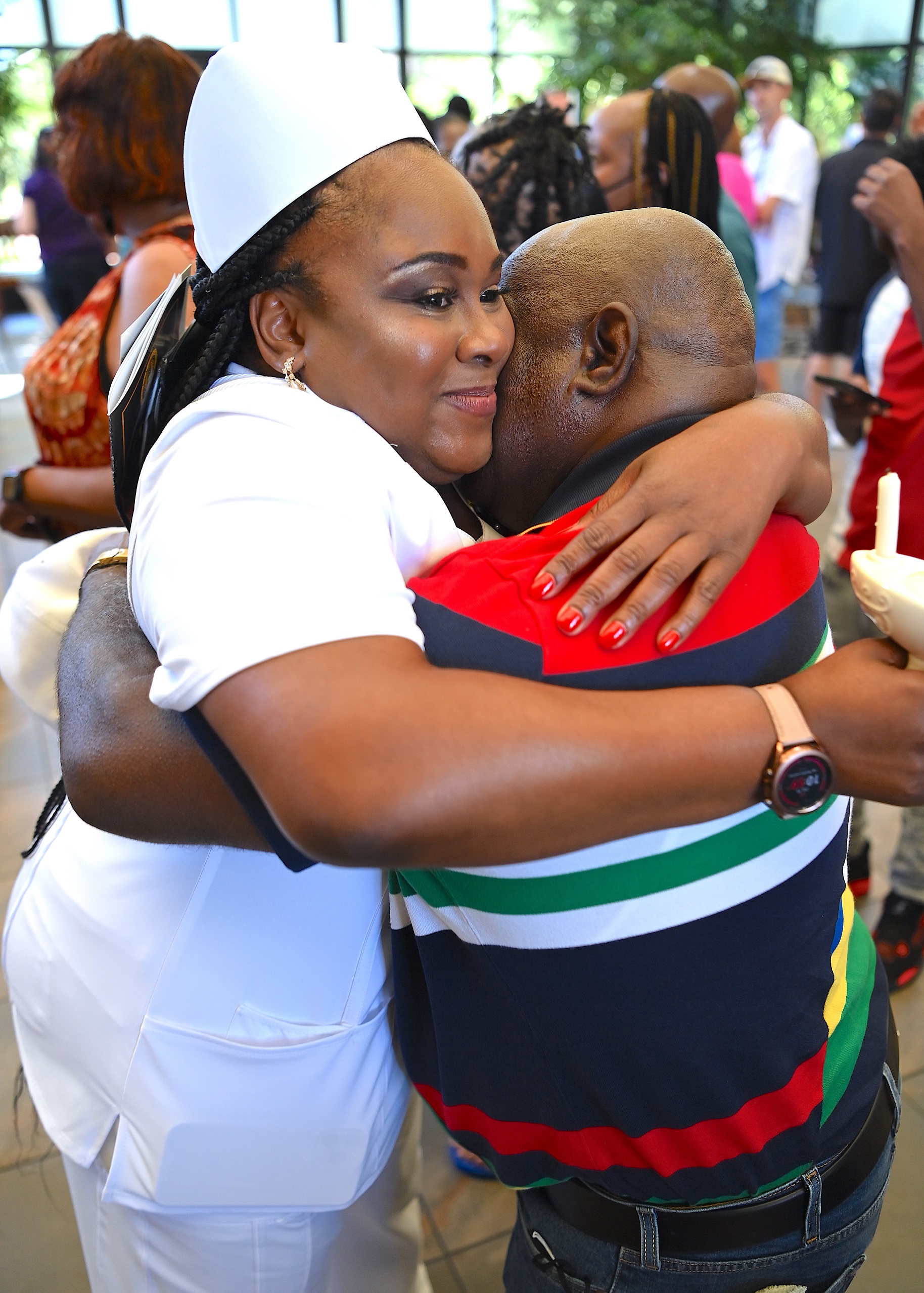 A nursing graduate hugs a loved one after the pinning ceremony.