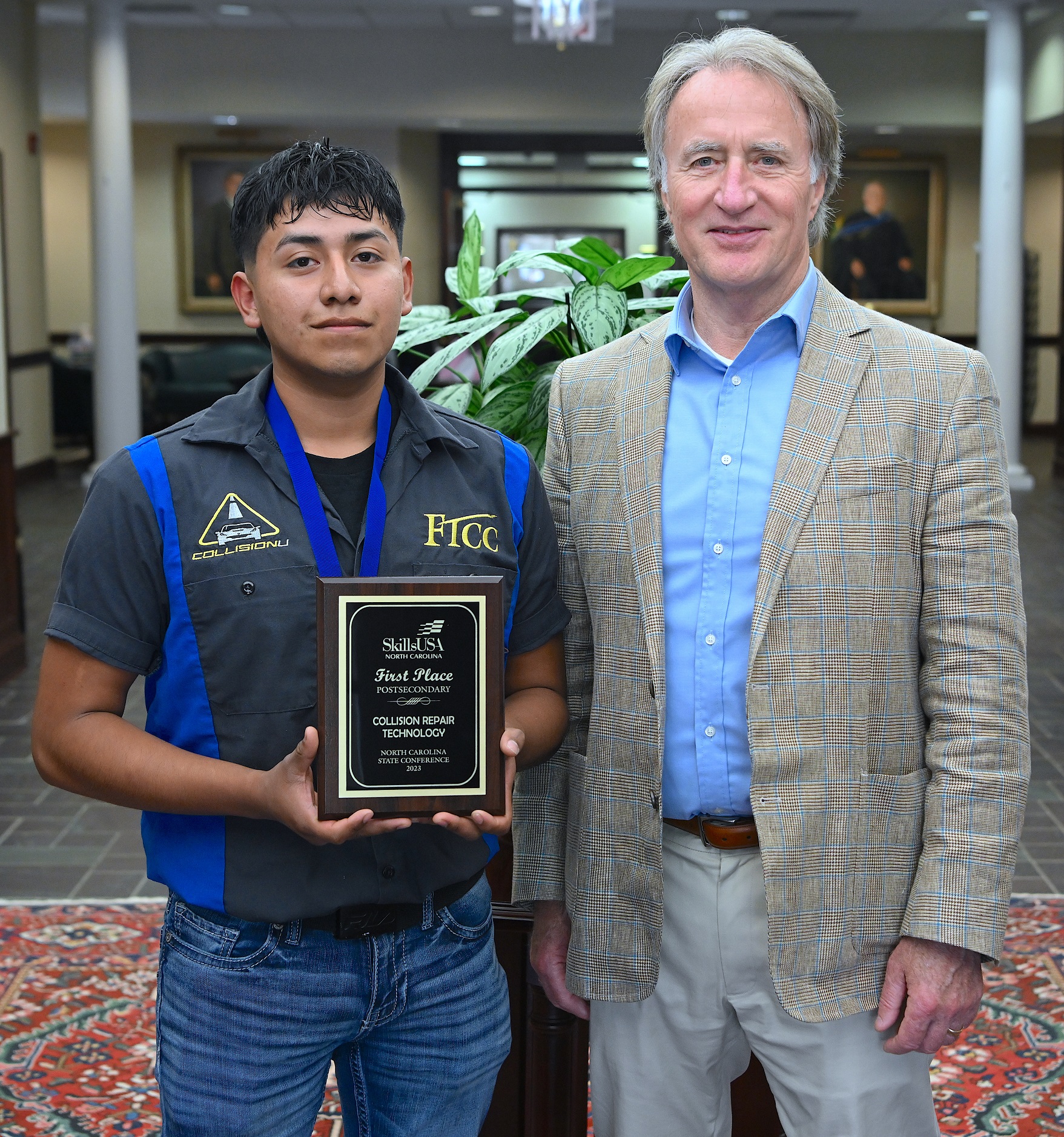 Hector Santos Medina (1st place, Collision Repair Technology) stands with FTCC President Dr. Mark Sorrells.