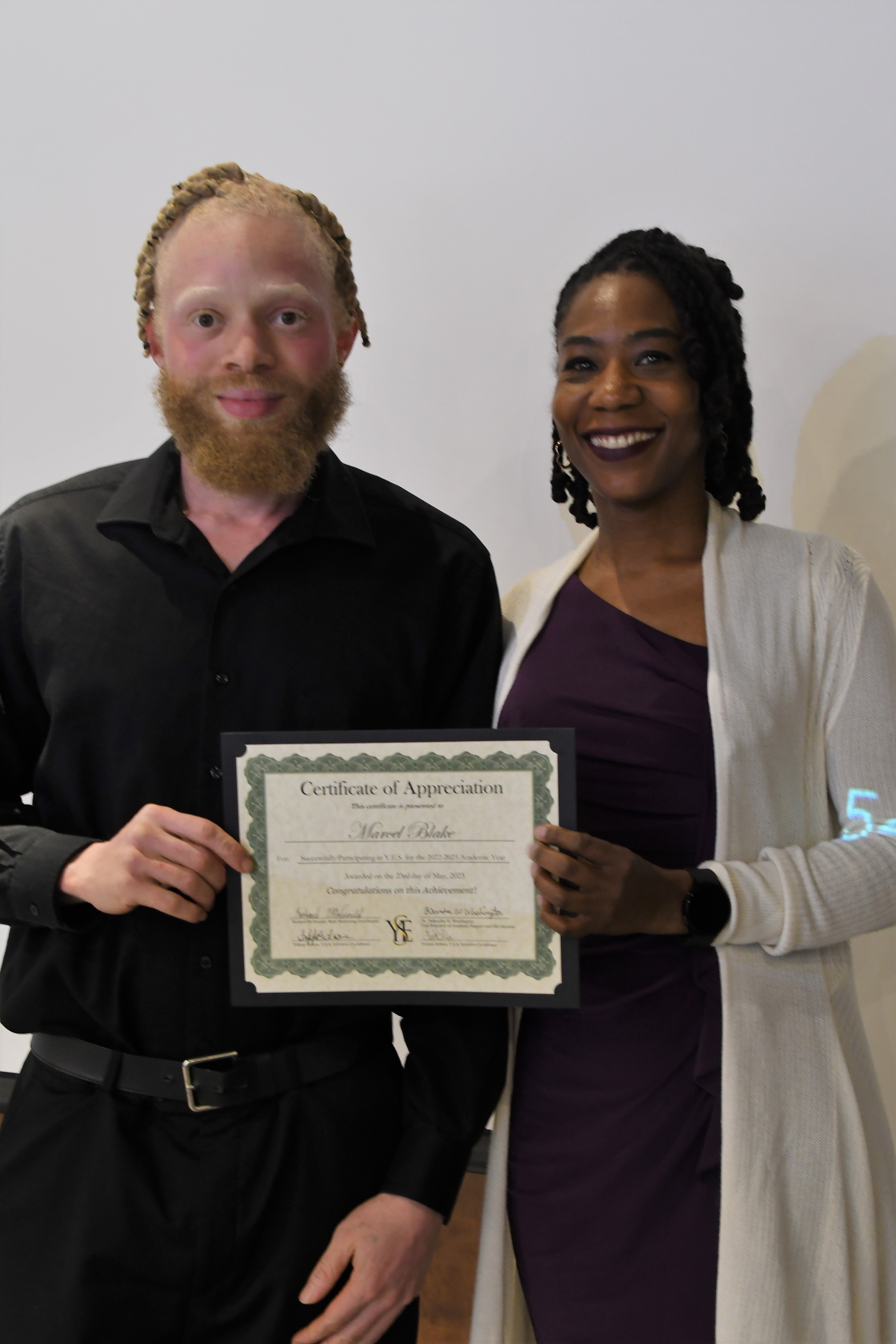 A student receives his Certificate of Appreciate for participating in the YES Initiative.