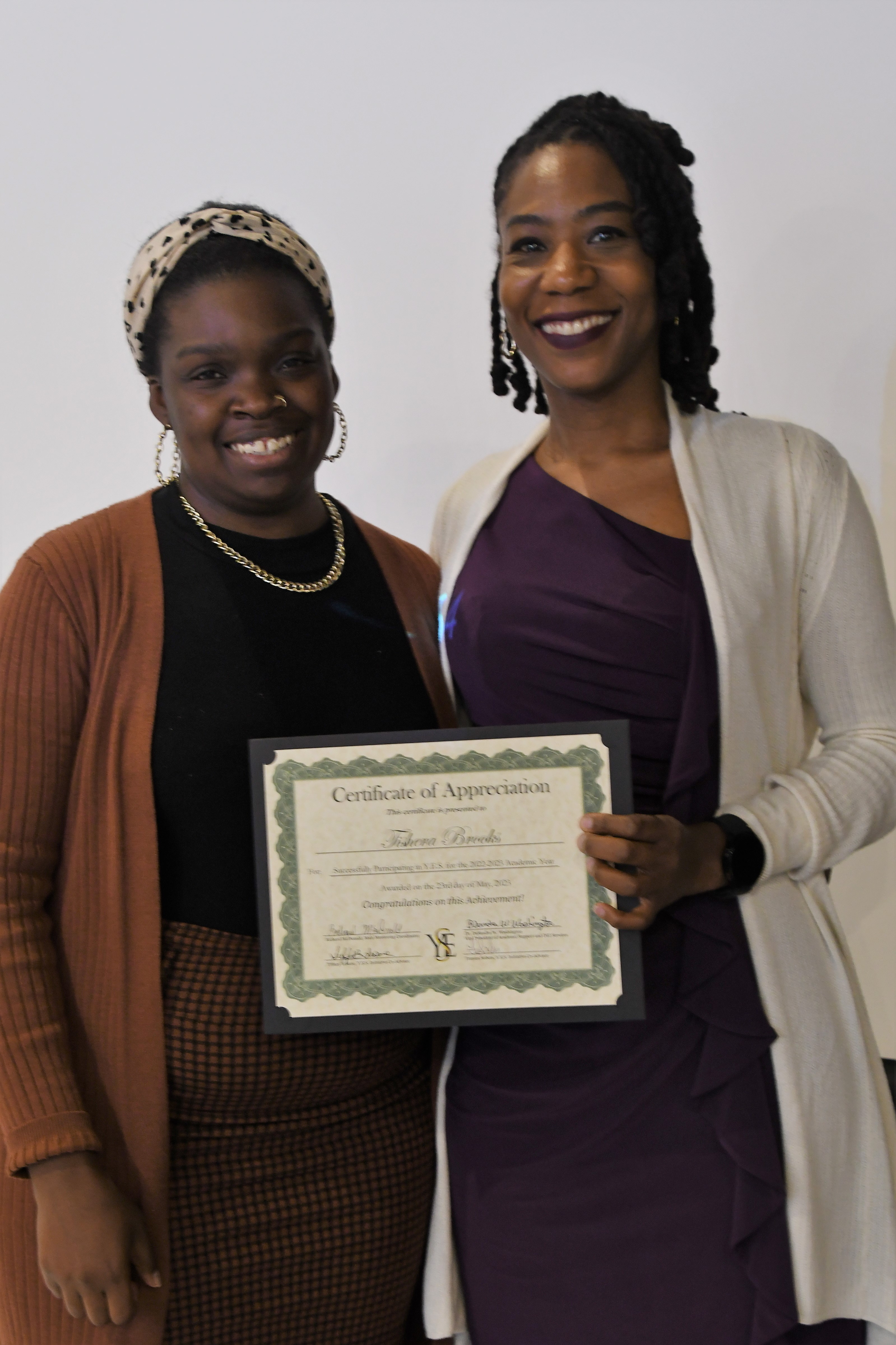 A student receives her Certificate of Appreciate for participating in the YES Initiative.