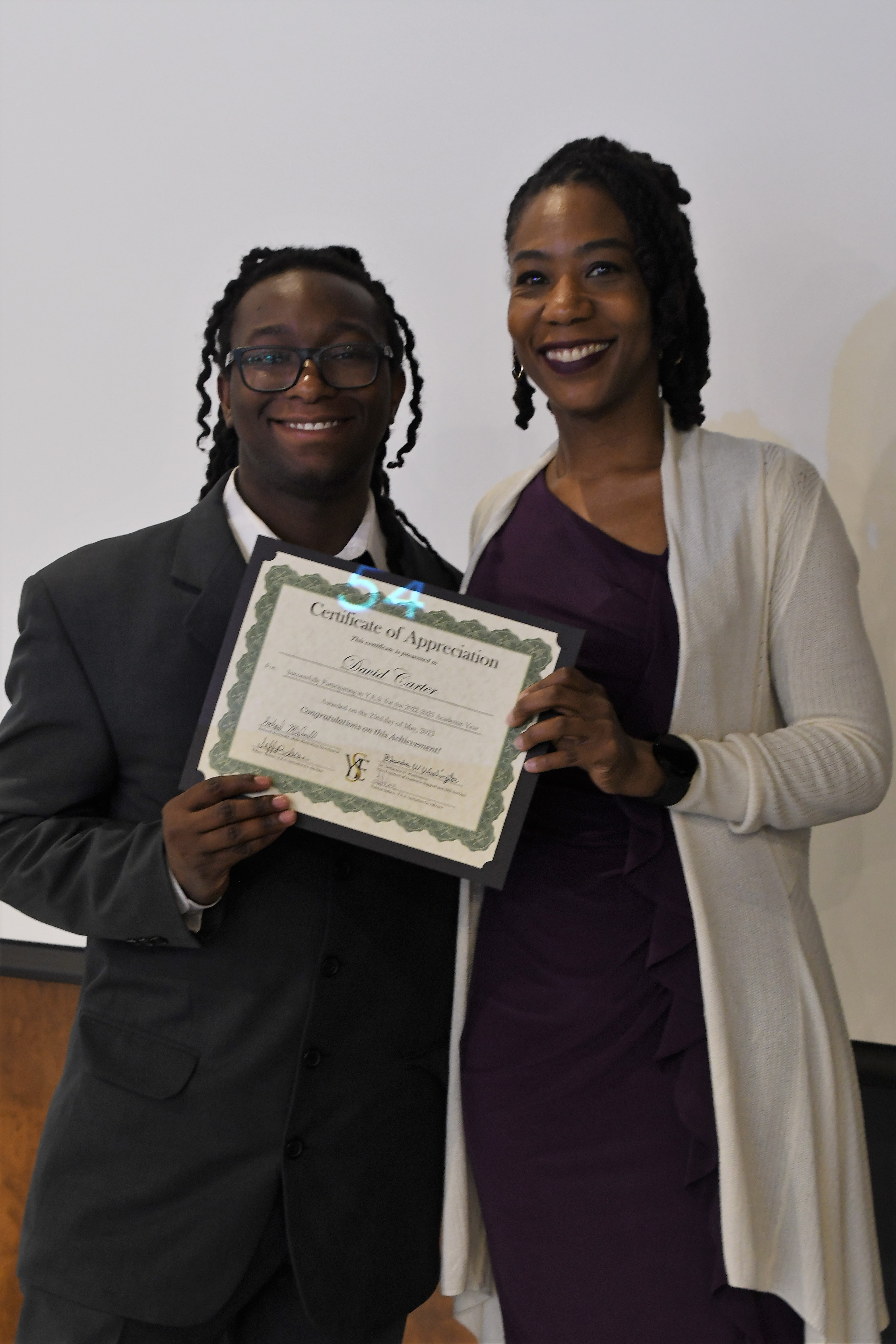 A student receives his Certificate of Appreciate for participating in the YES Initiative.
