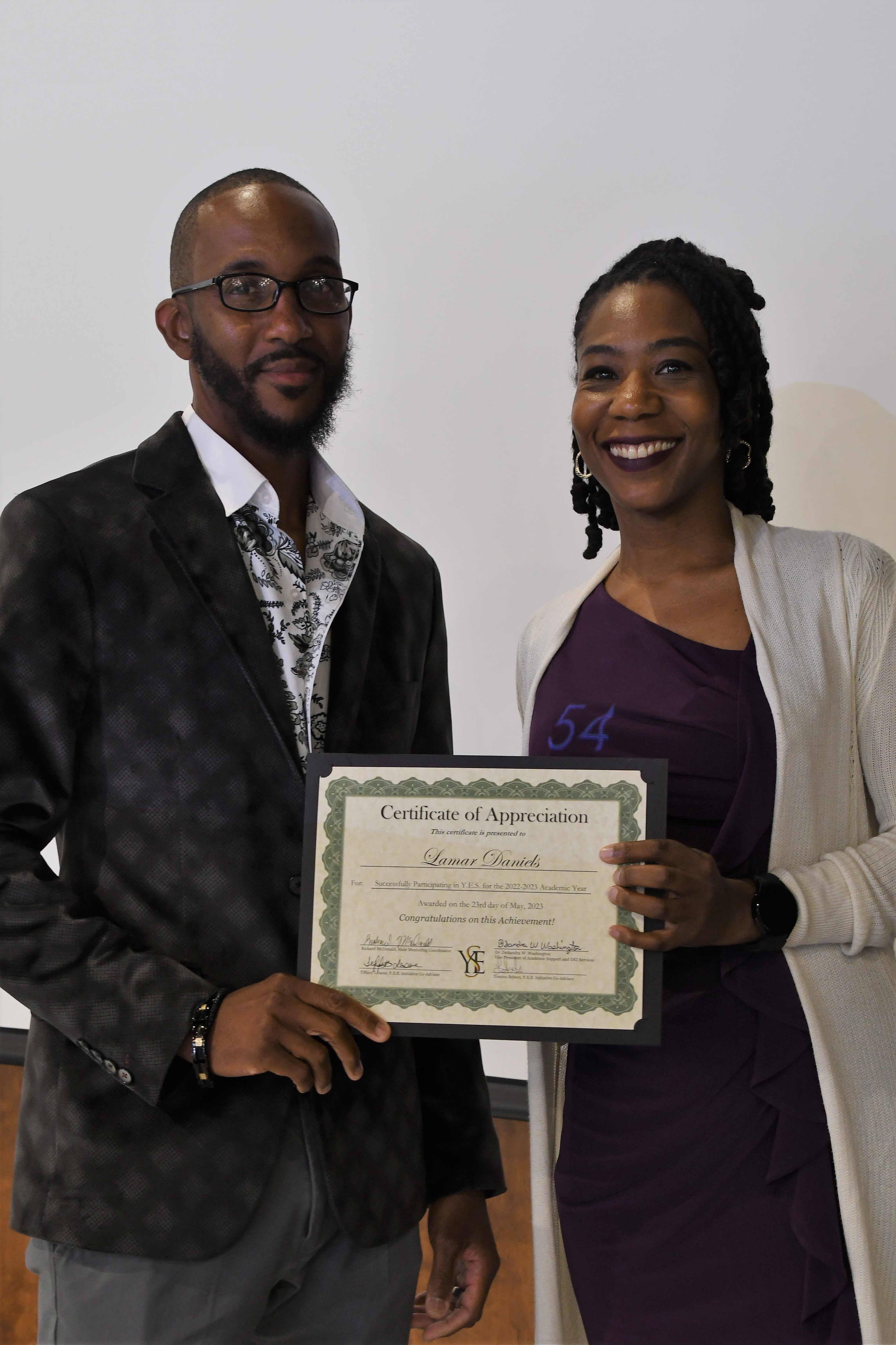 A student receives his Certificate of Appreciate for participating in the YES Initiative.