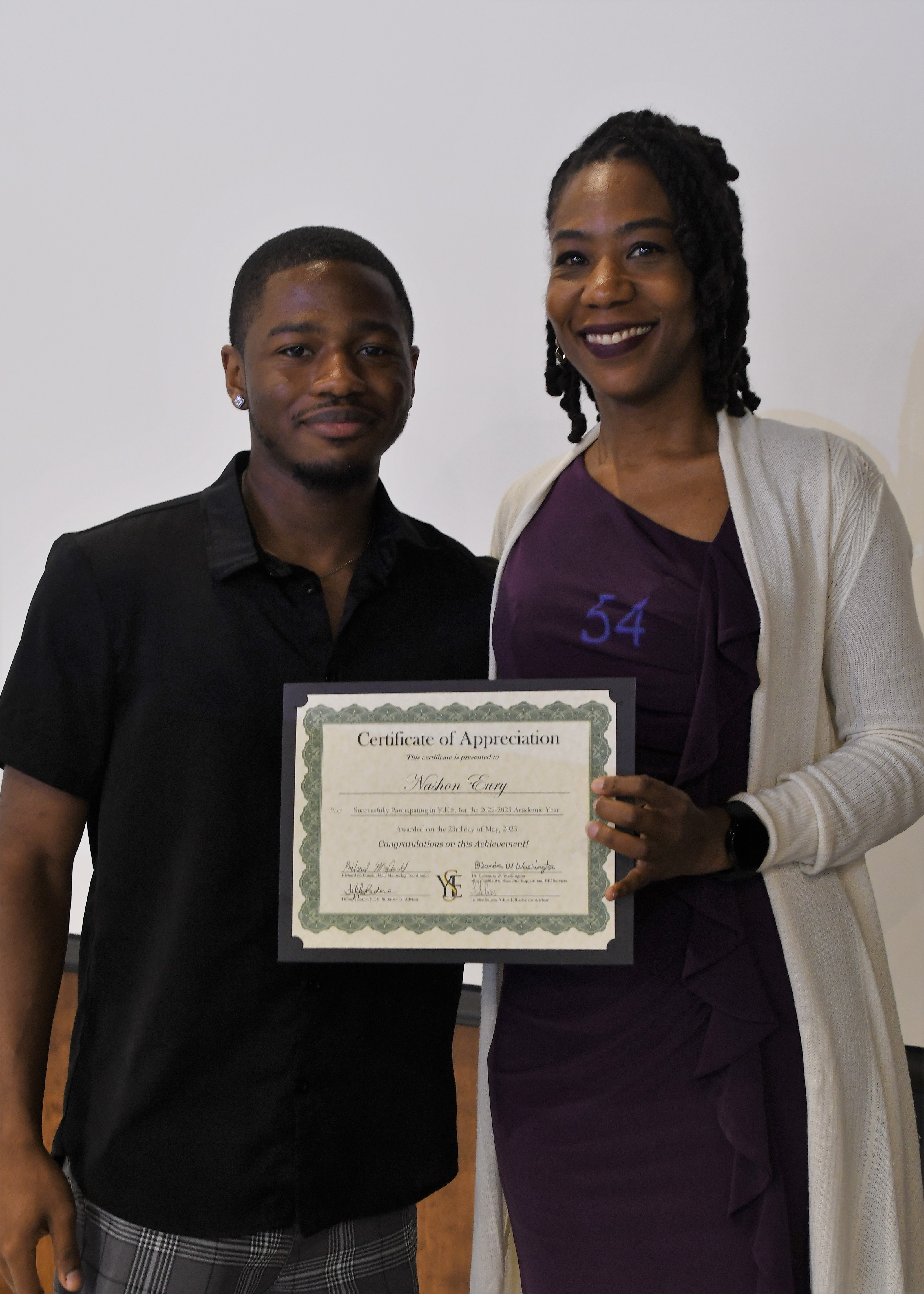 A student receives his Certificate of Appreciate for participating in the YES Initiative.