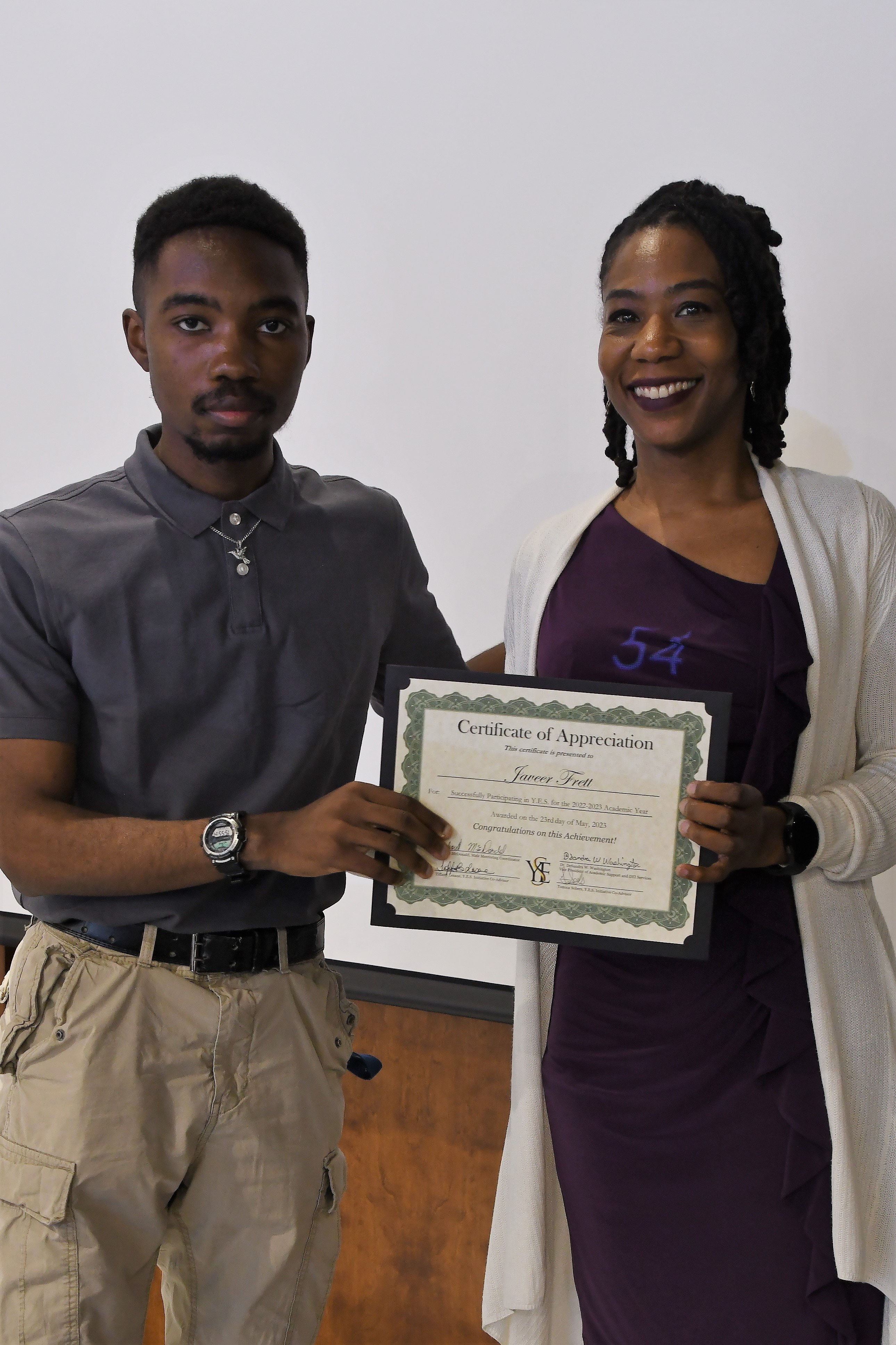 A student receives his Certificate of Appreciate for participating in the YES Initiative.