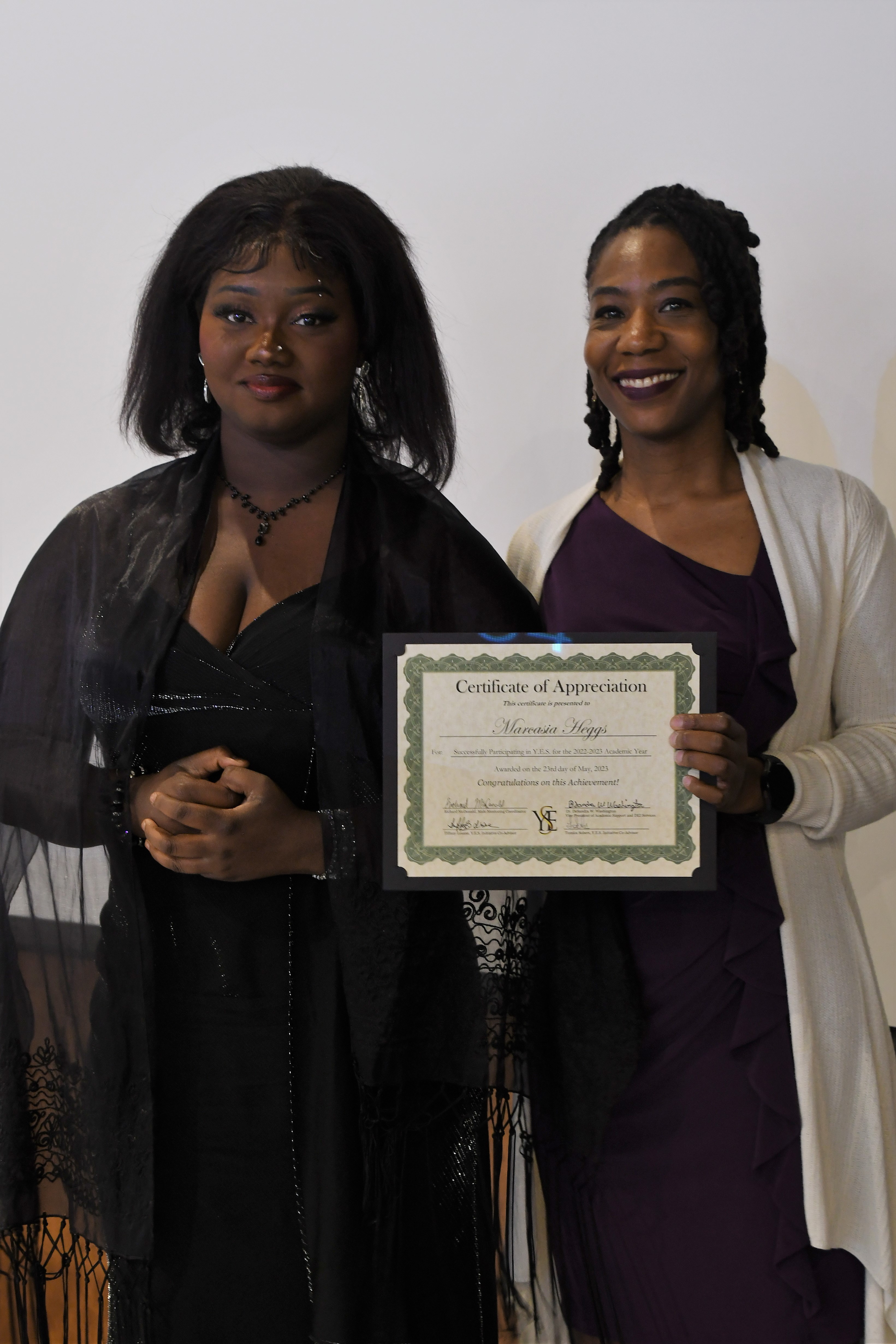 A student receives her Certificate of Appreciate for participating in the YES Initiative.