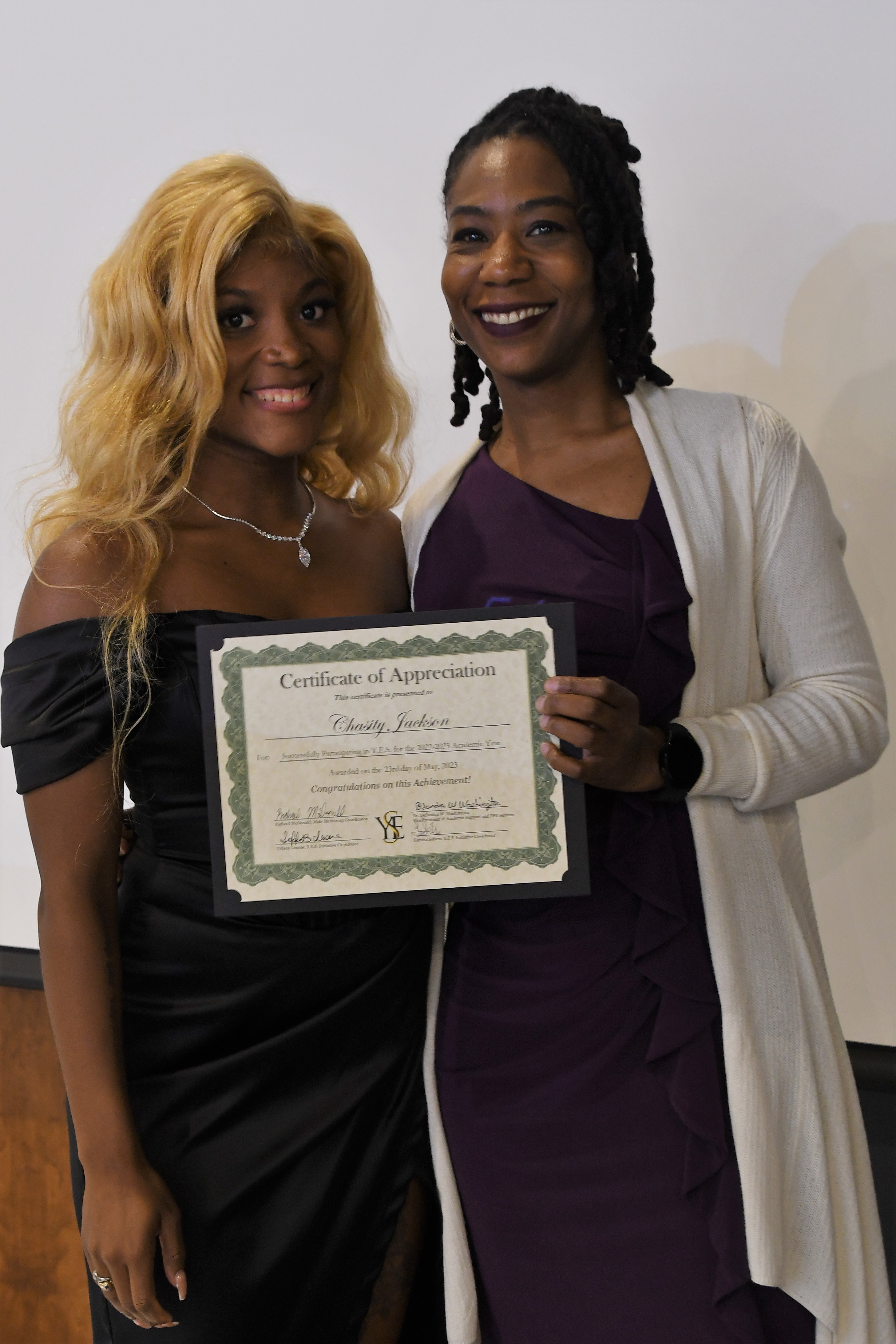 A student receives her Certificate of Appreciate for participating in the YES Initiative.