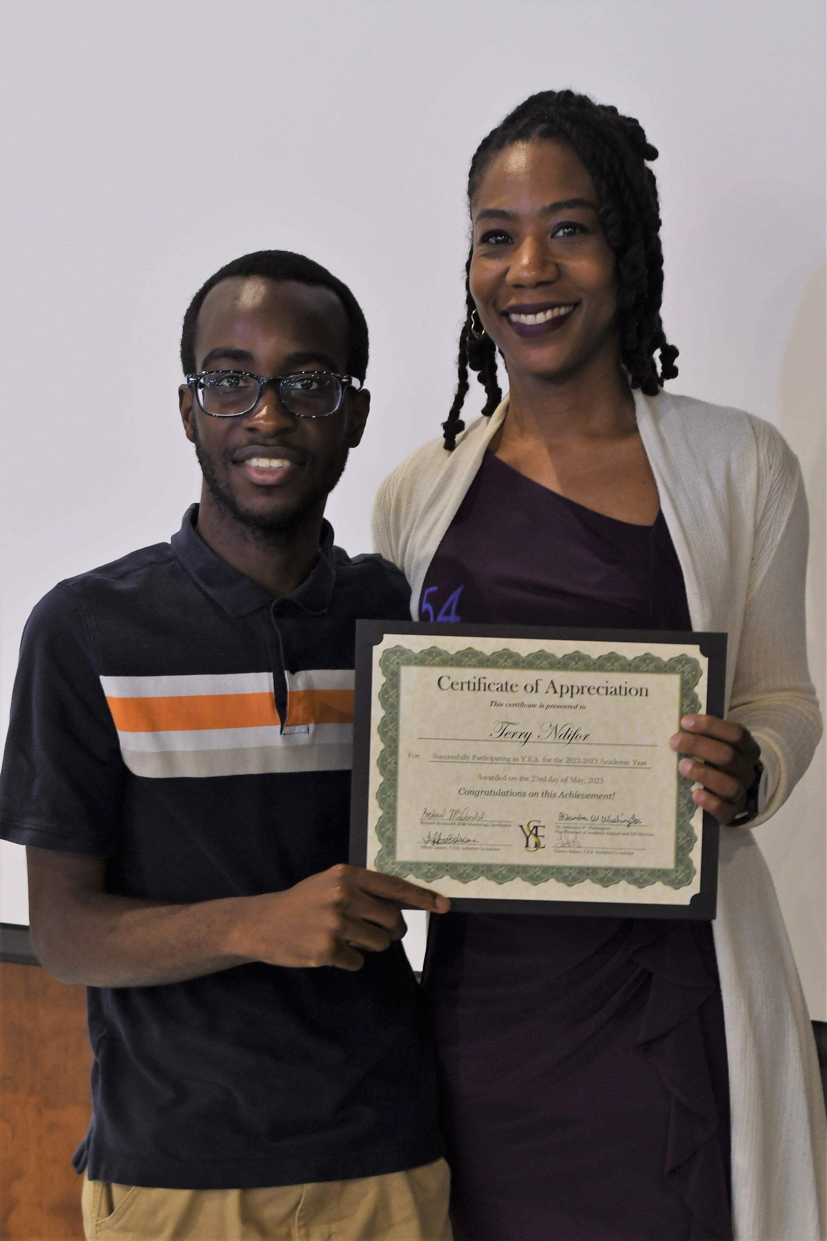 A student receives his Certificate of Appreciate for participating in the YES Initiative.