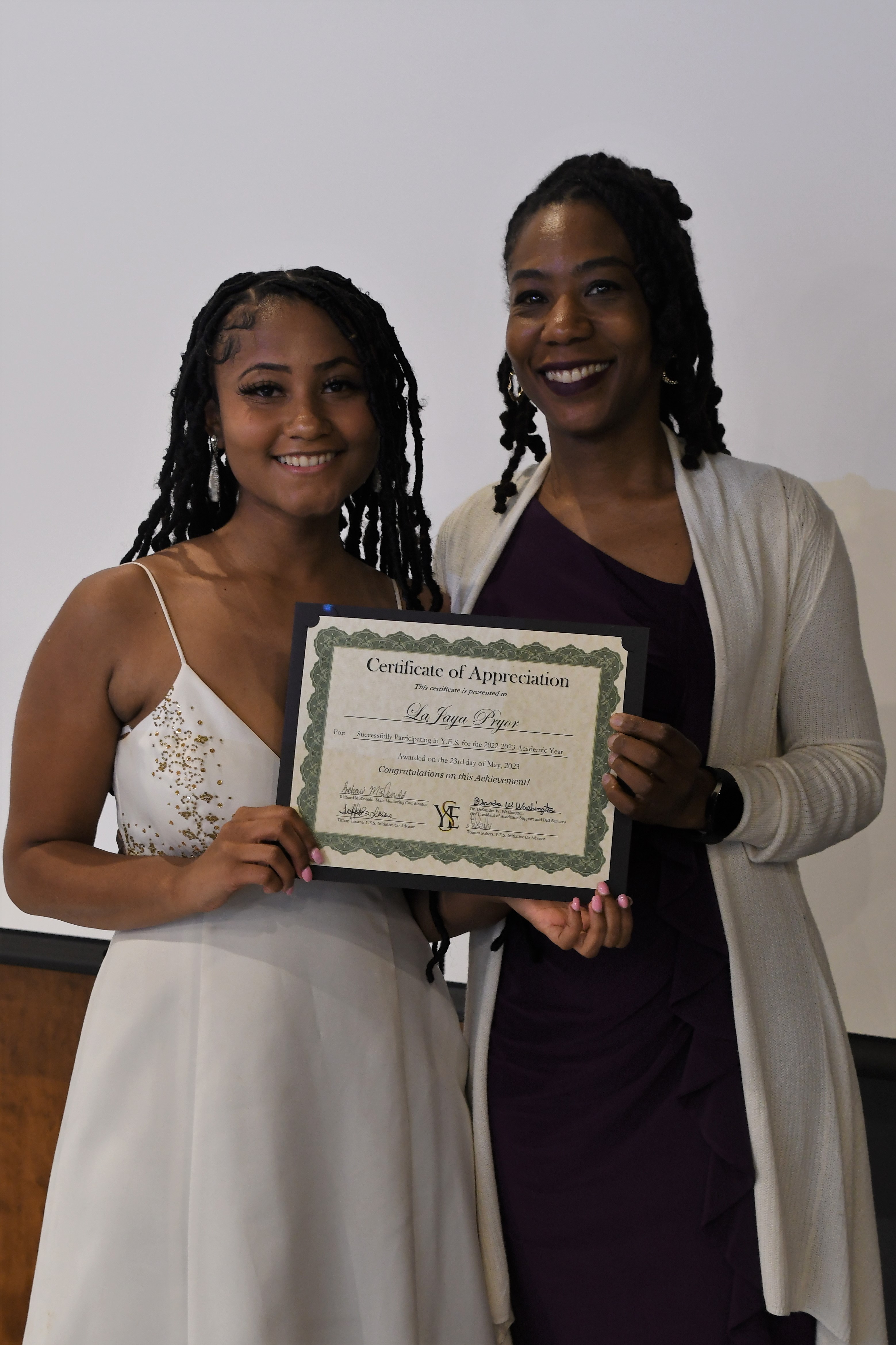 A student receives her Certificate of Appreciate for participating in the YES Initiative.