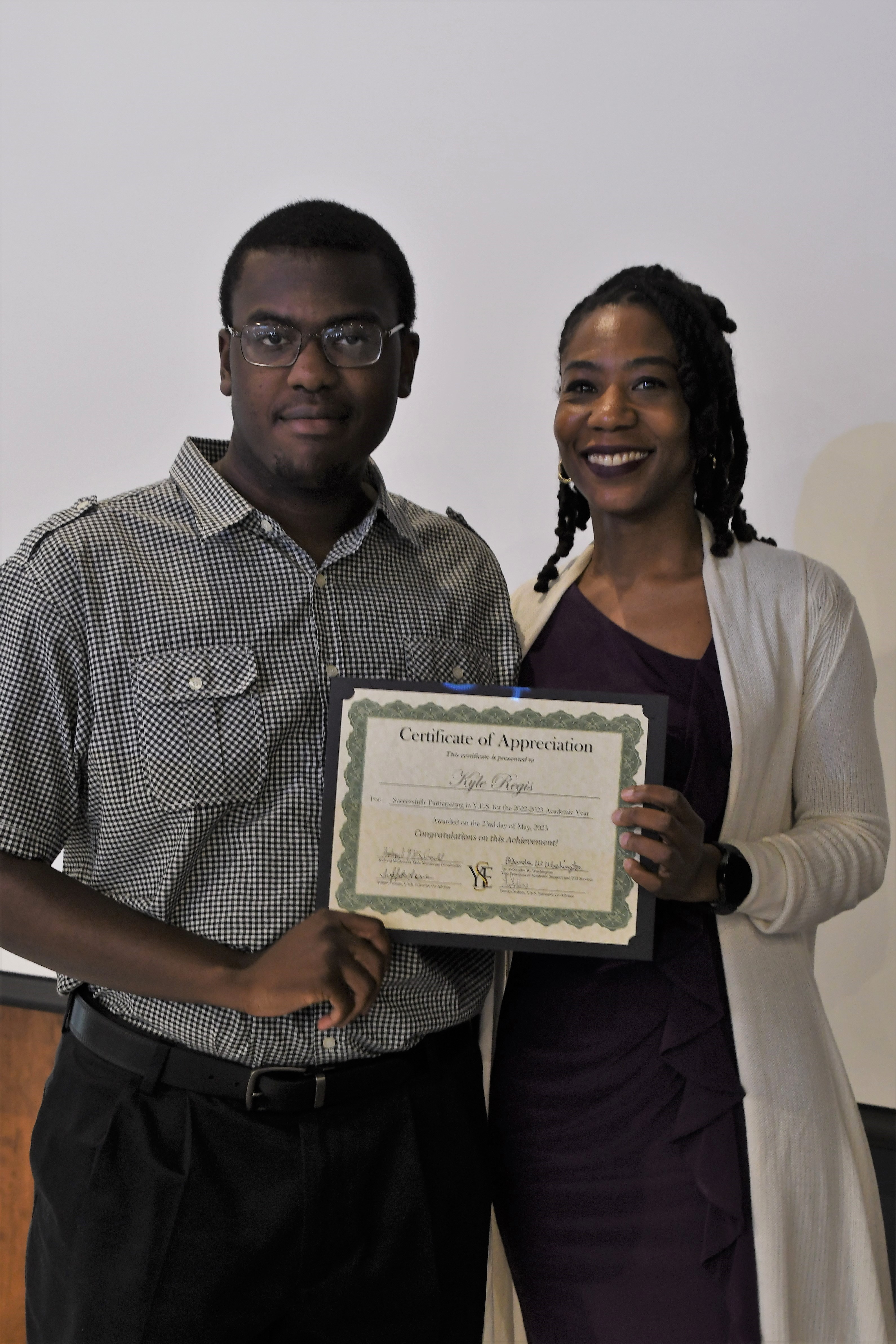 A student receives his Certificate of Appreciate for participating in the YES Initiative.